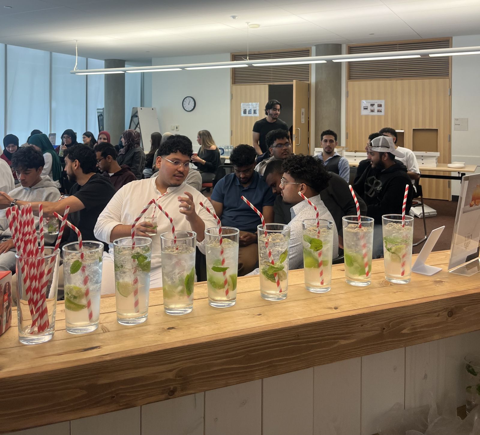 A row of fresh mint mocktails on the Layl bar in front of a full room of guests
